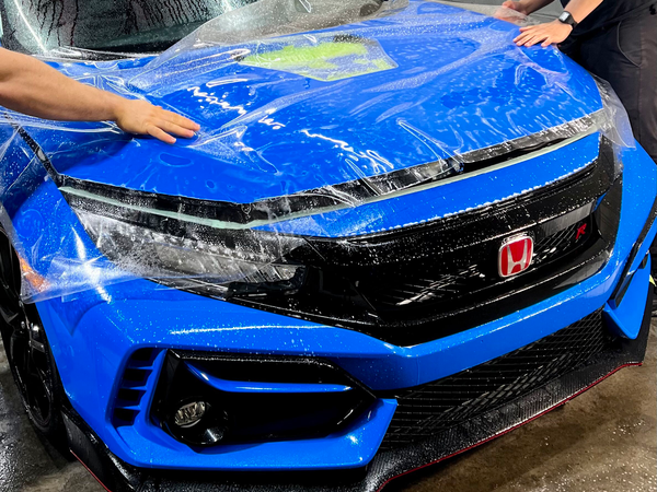 Putting a Protection film on a blue car