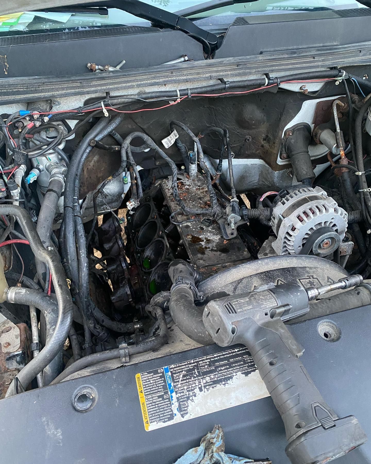 Burned car engine bay with charred wiring and damaged components under the hood