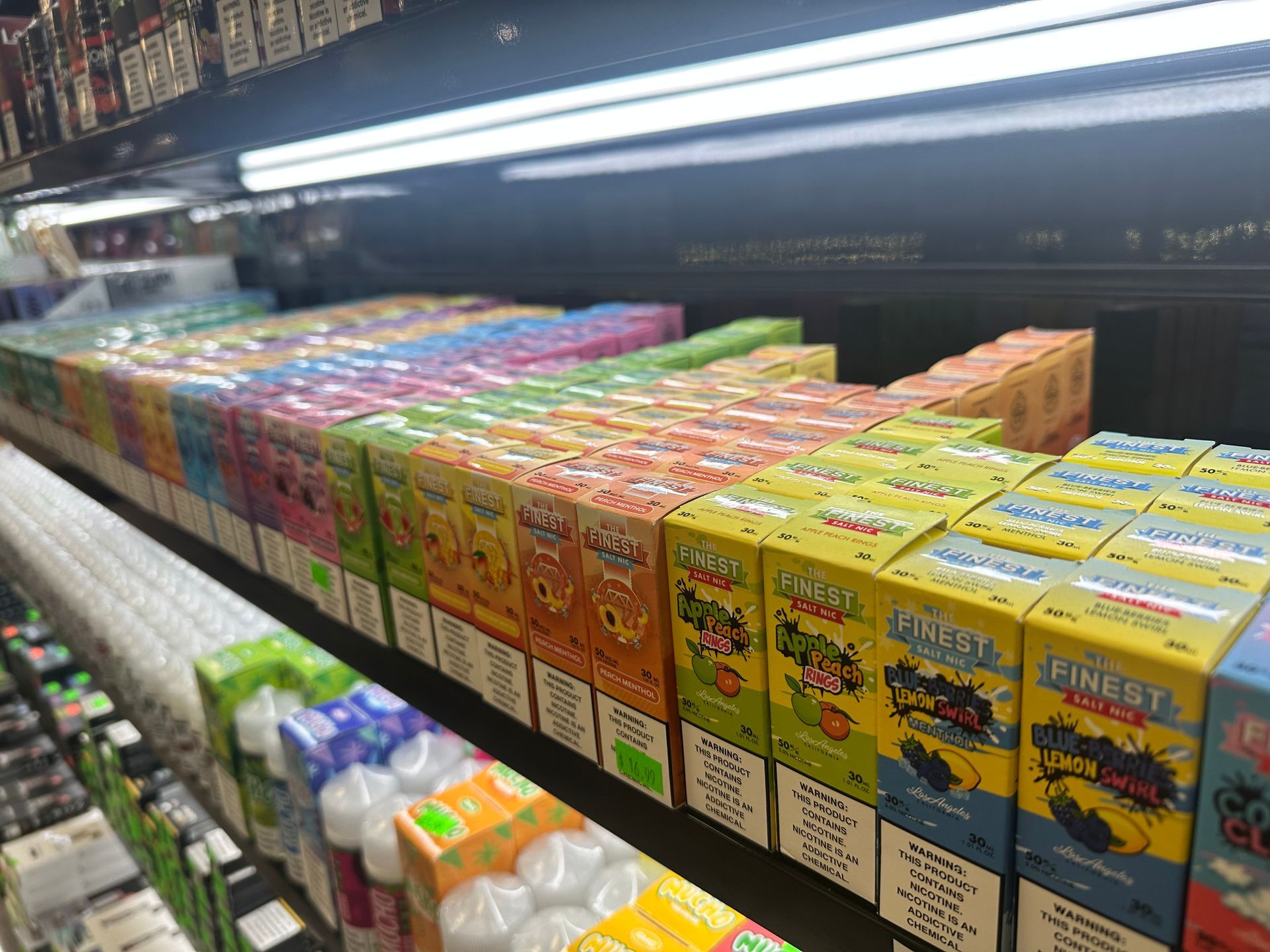 A shelf filled with boxes of e liquid in a store.