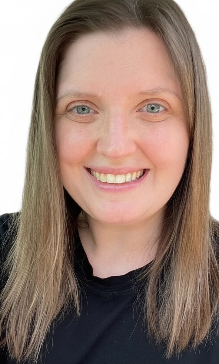 A woman wearing glasses and braids is smiling for the camera