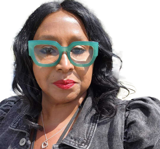 A woman wearing a denim jacket and green glasses