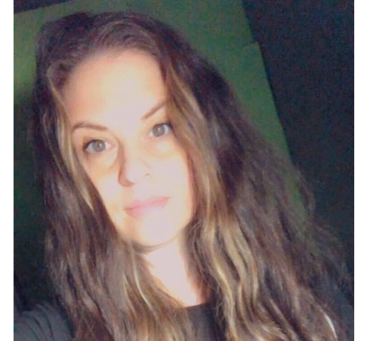 A woman with long brown hair is taking a selfie.