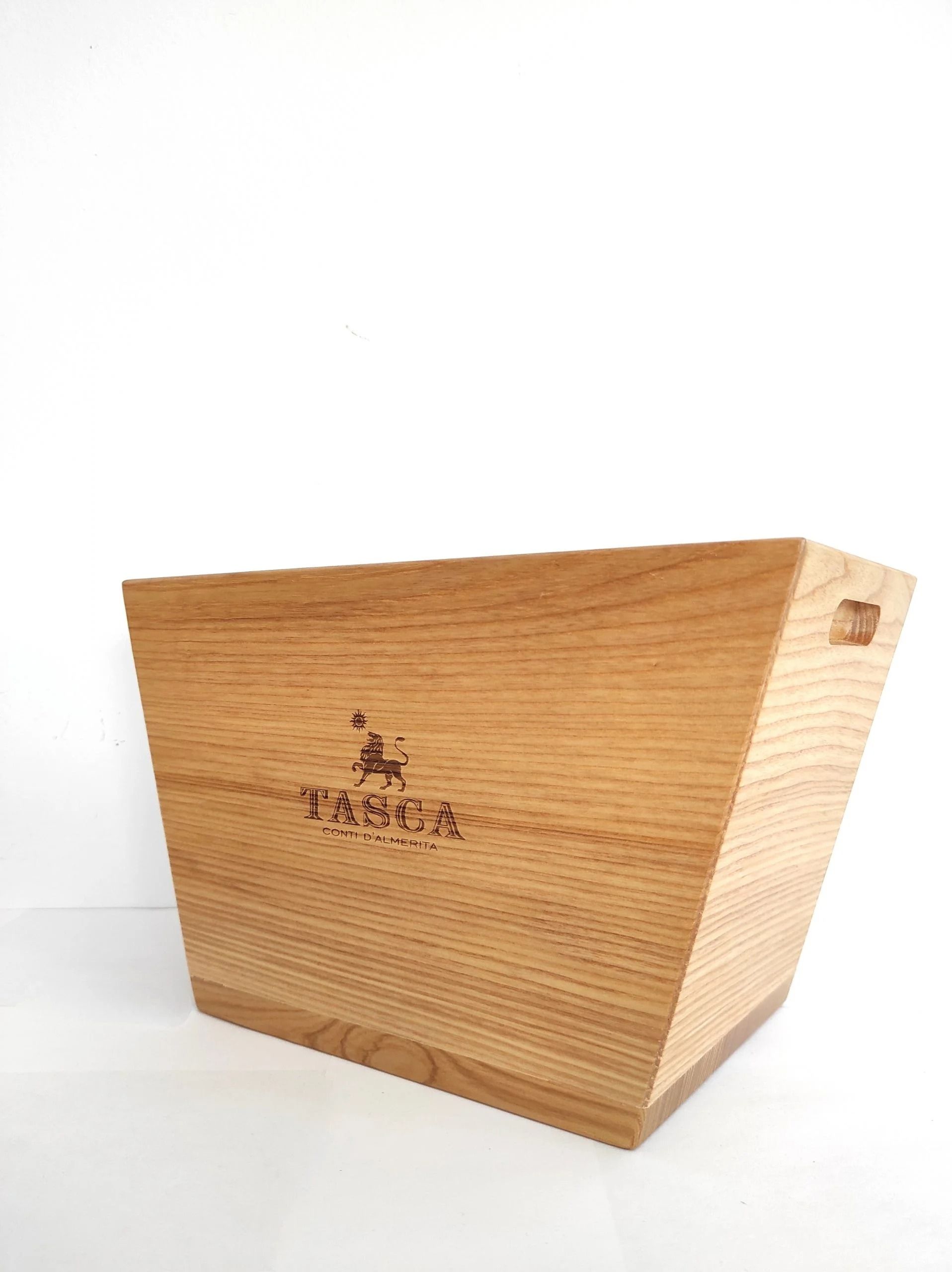 Cassa in legno chiaro con un piccolo logo, isolata su sfondo bianco.