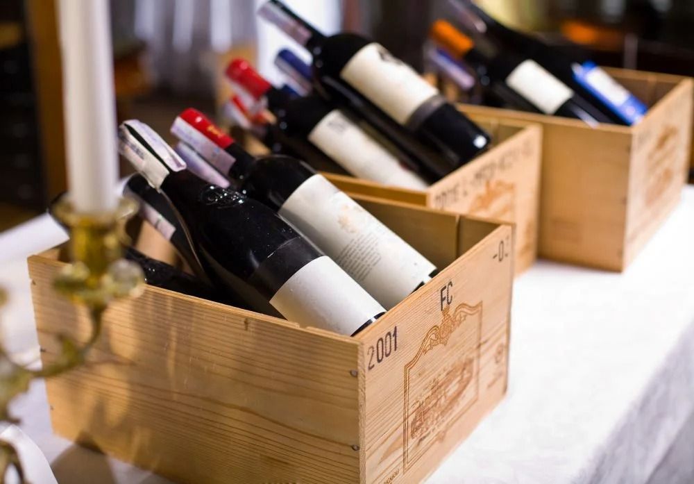 Bottiglie di vino in casse di legno su un tavolo in un'azienda vinicola o in un negozio.