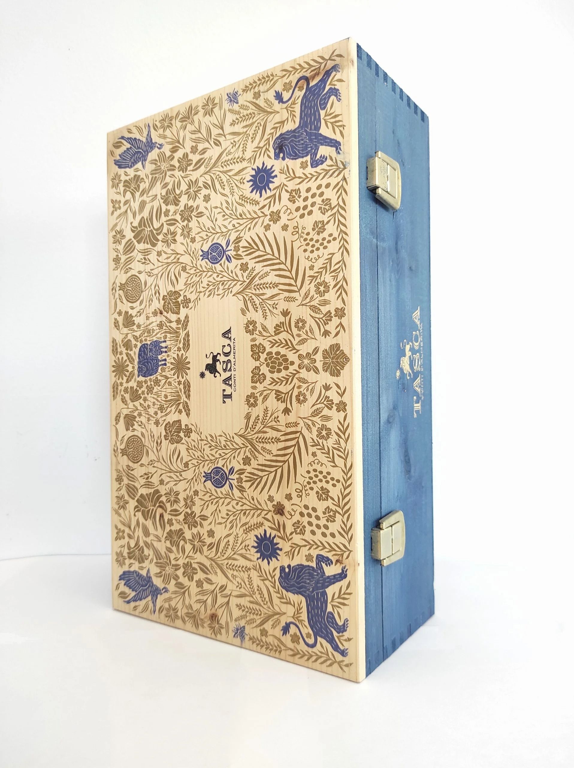 Scatola decorativa blu e oro con coperchio a cerniera, aperta ad angolo su sfondo bianco.