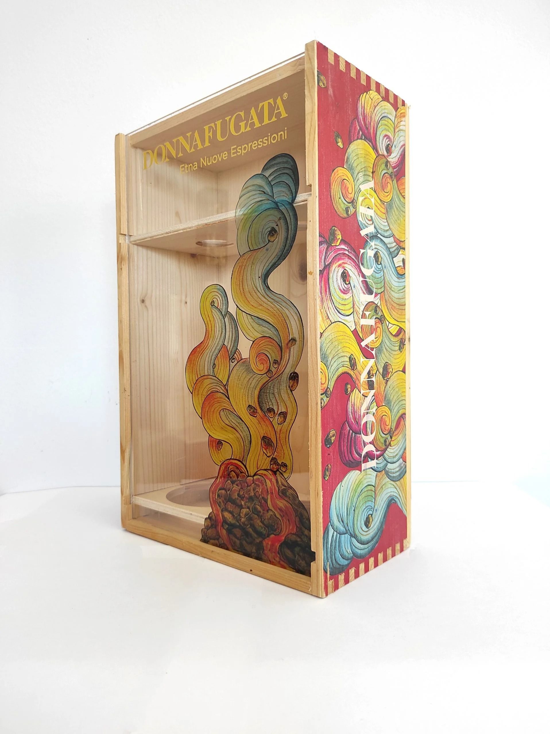 Scatola espositiva decorativa in legno con un colorato collage astratto e l'illustrazione di un uccello sul lato.