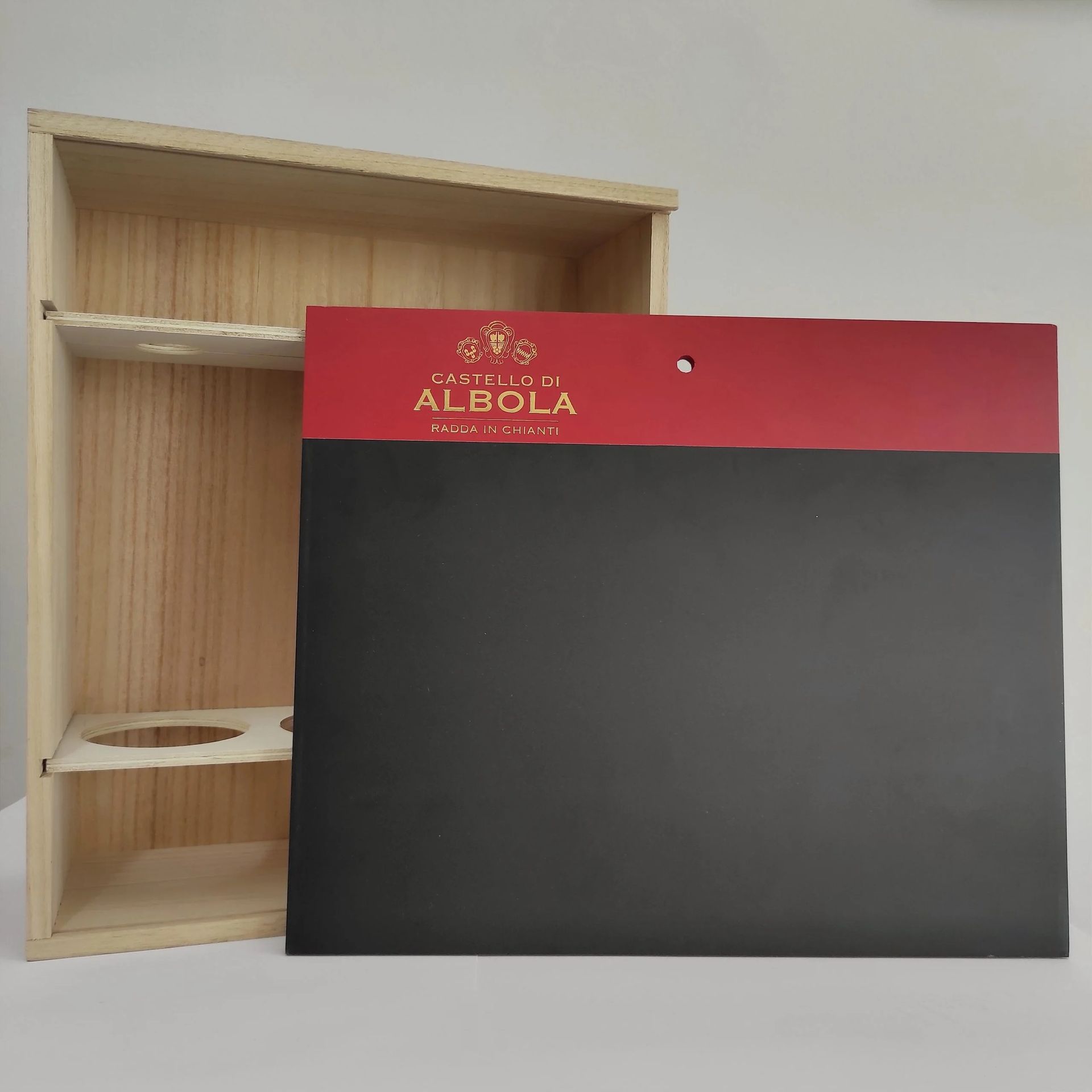 Mobiletto di legno aperto accanto a un pannello di cartone nero e rosso