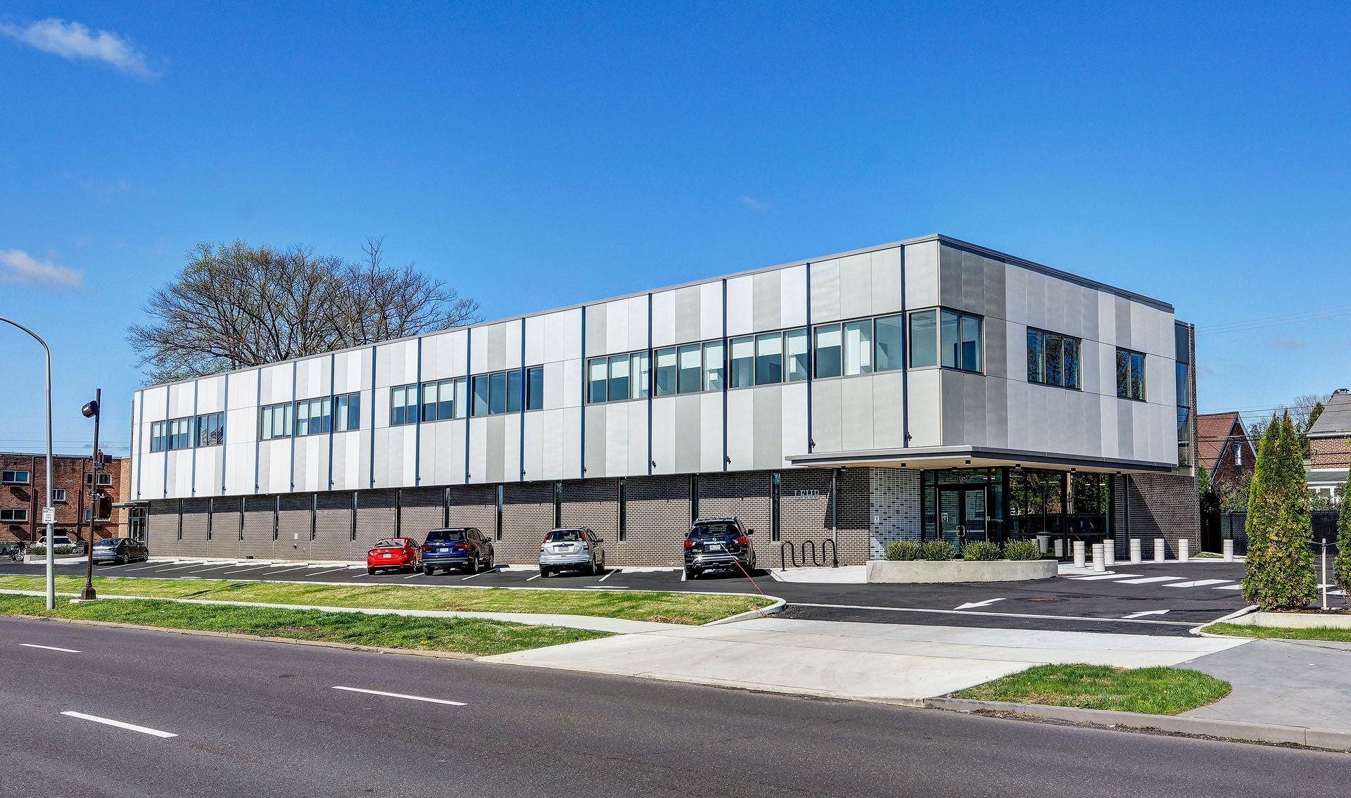 A large white building with cars parked in front of it.
