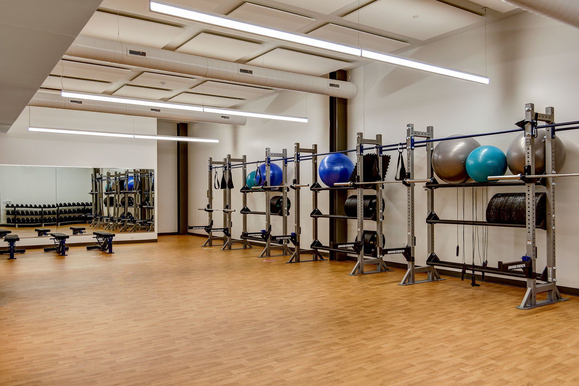A gym with a lot of exercise balls and a mirror