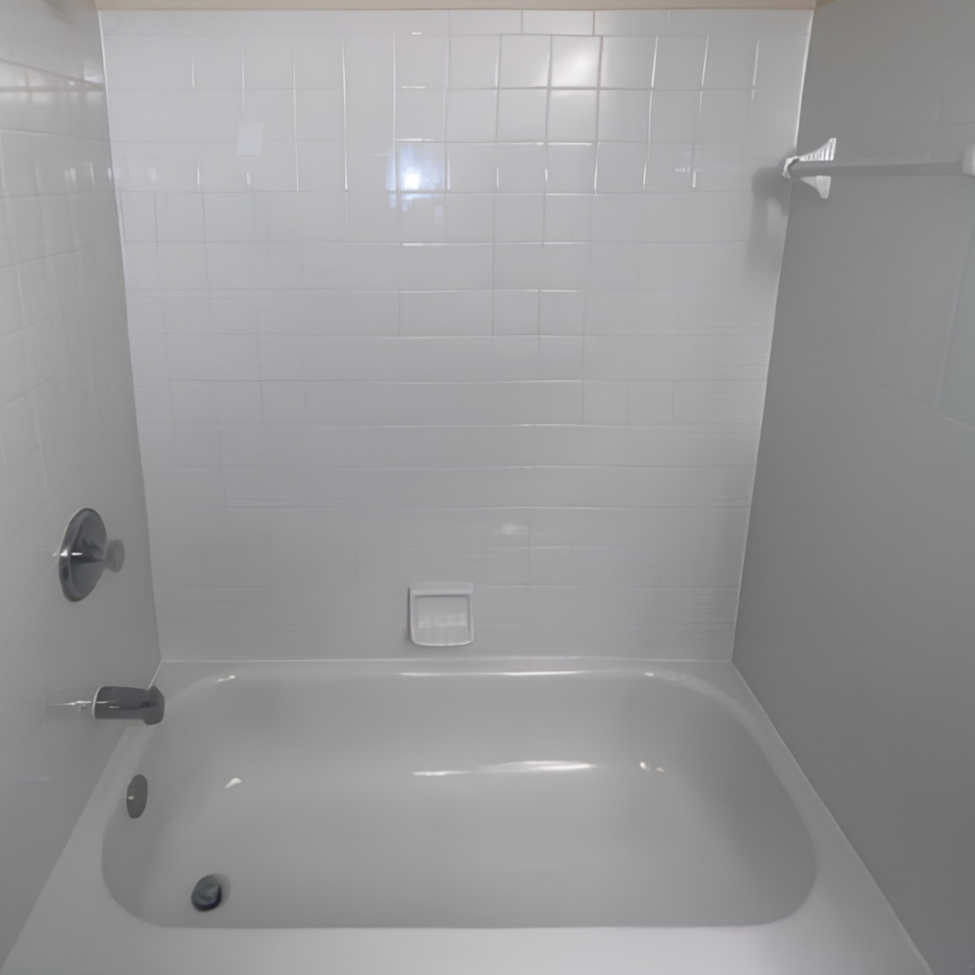 White bathtub and tiled shower alcove in a bathroom, with chrome fixtures and a soap ledge.