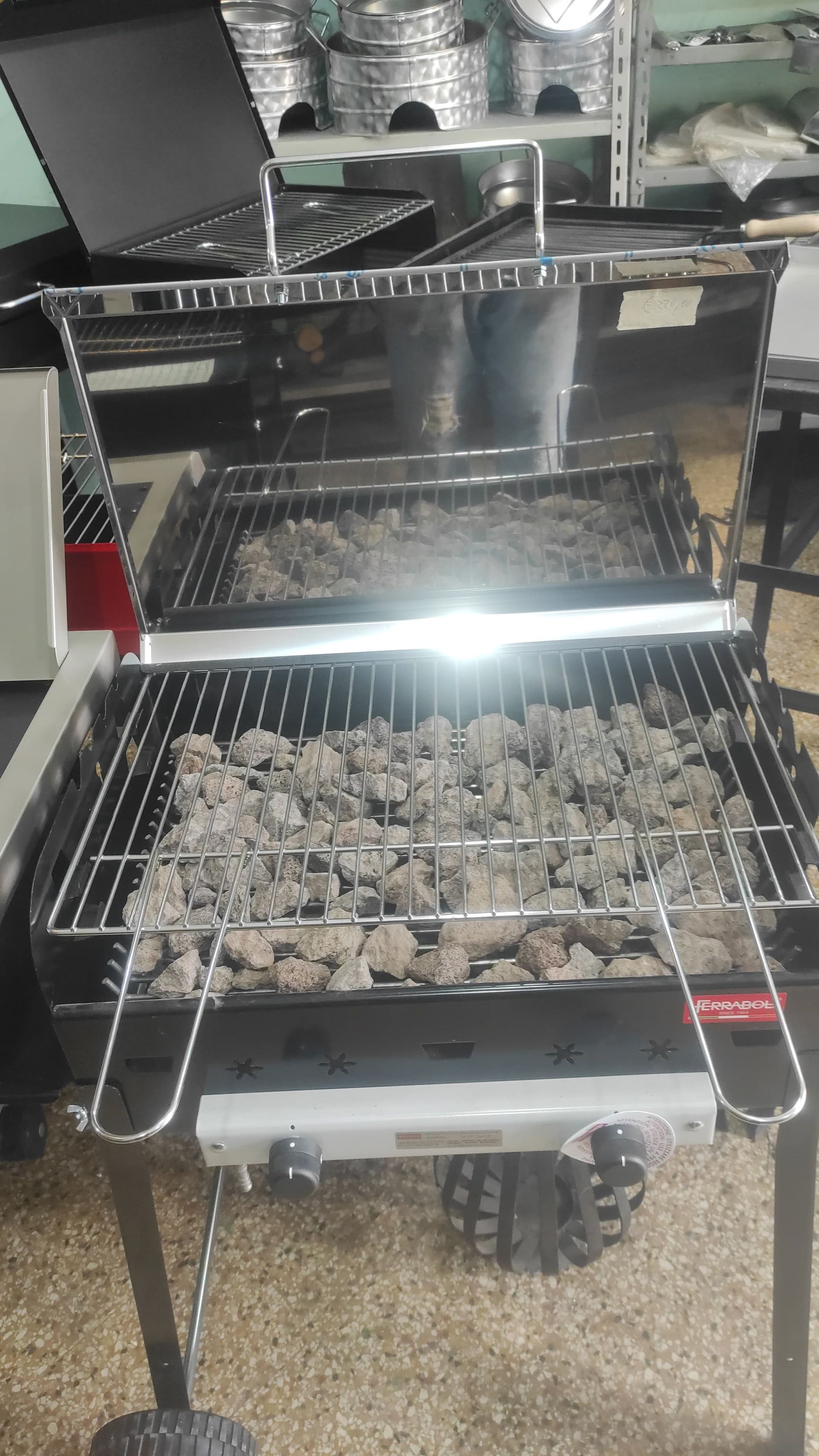 Barbecue a carbone, griglie ricoperte di cenere, acciaio inox, installazione all'aperto.