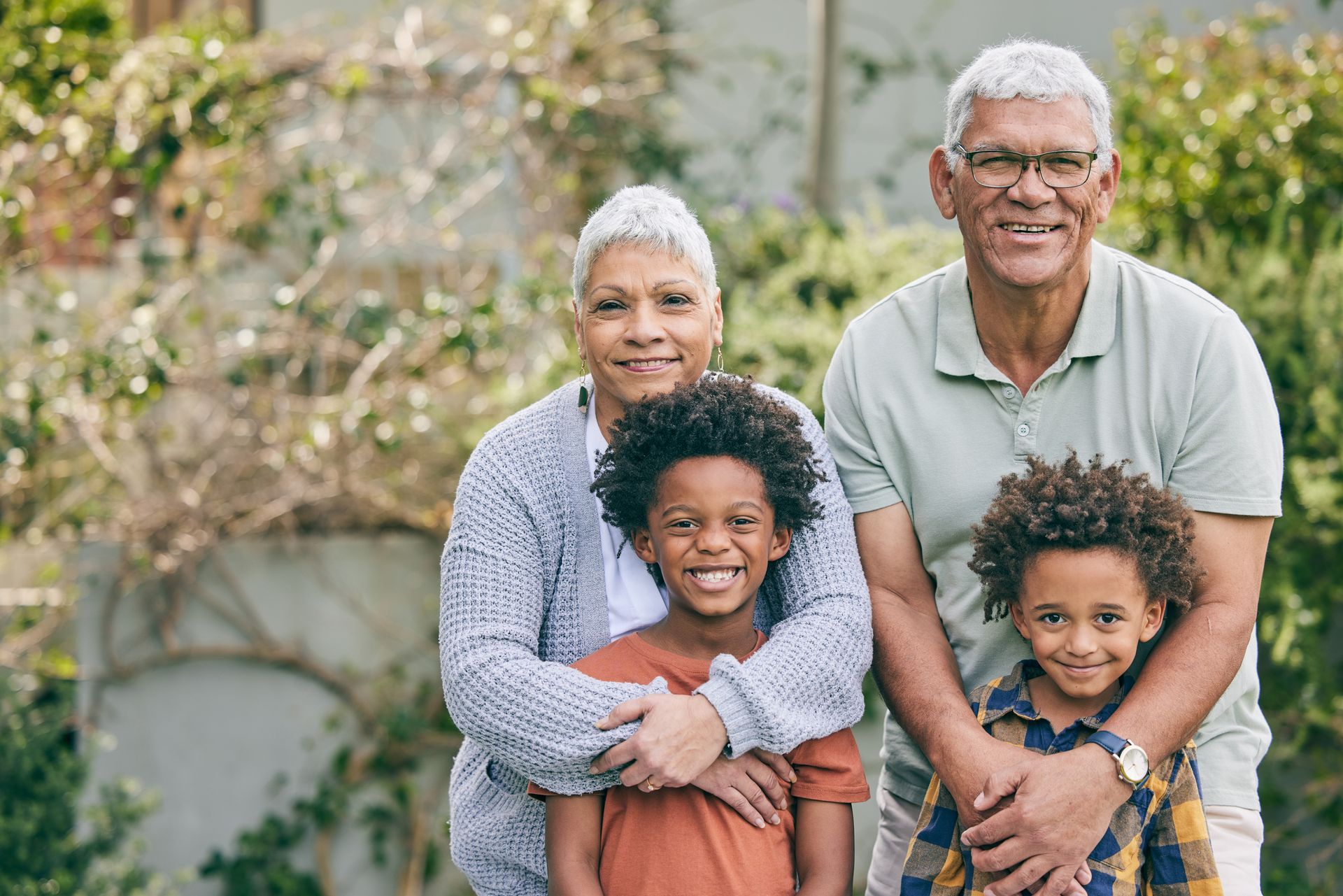 A group of older people are posing for a picture in a park.
