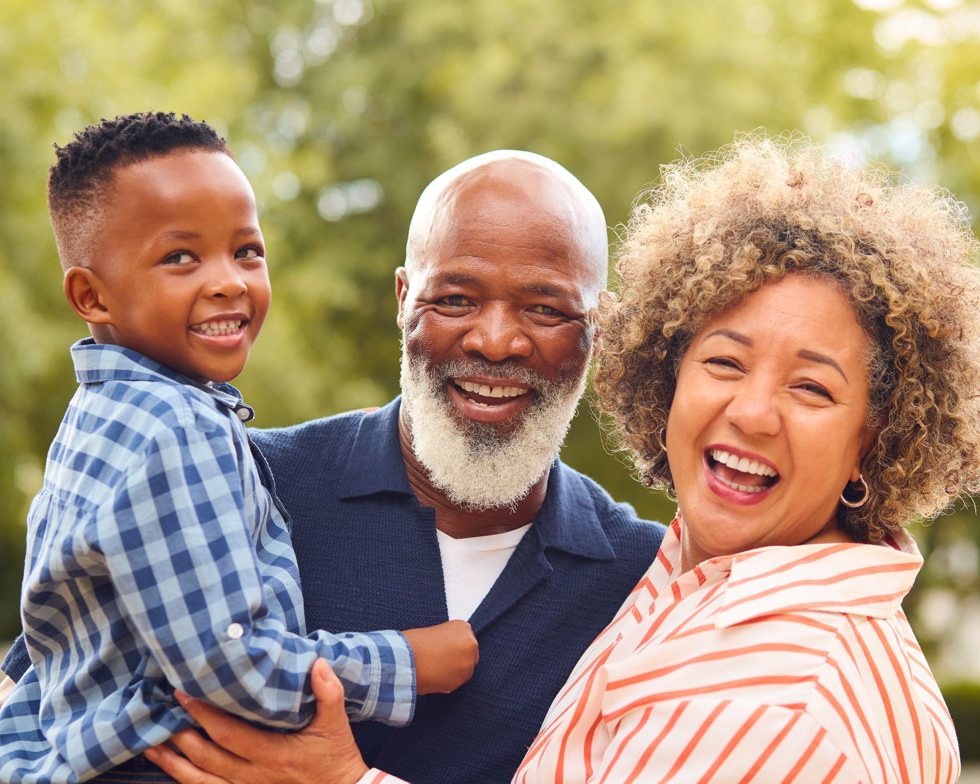 A family is sitting on the grass in a park.
