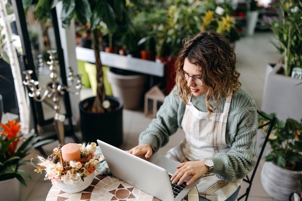 Female small business owner working on a laptop to update her website's local business directories.