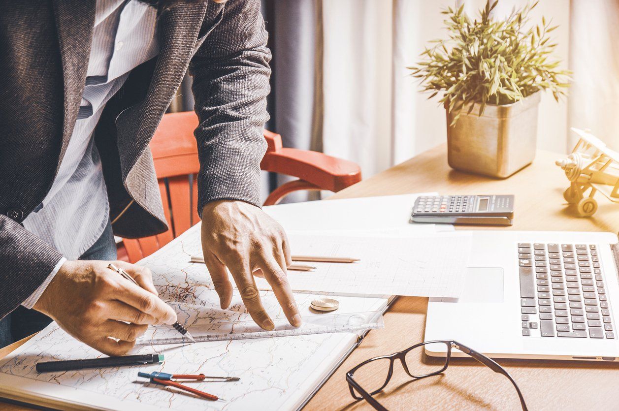 Male architect planning for his landscaping project in an office - building his landscaping portfolio for his business.