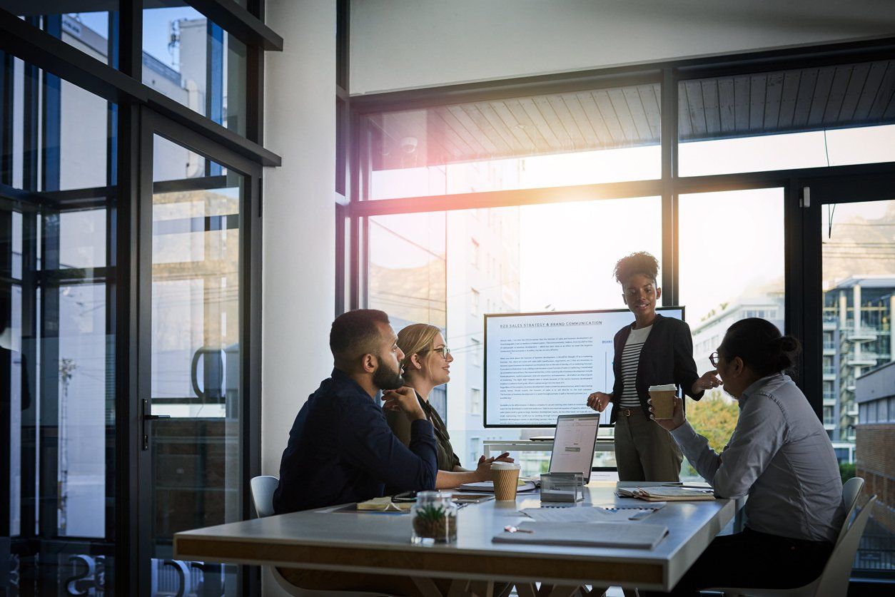 Team of business owners in an office having a meeting about their business' target customers.