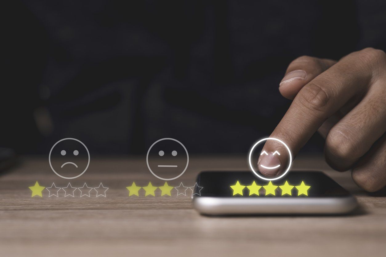 Person's hand touching a mobile phone to give 5-star online ratings to a home improvement business.