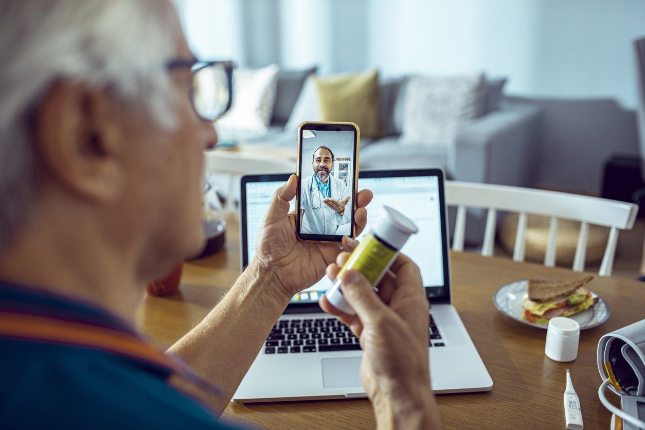 An idea of digital transformation in healthcare - male patient speaking with his doctor during a consultation using a mobile app.