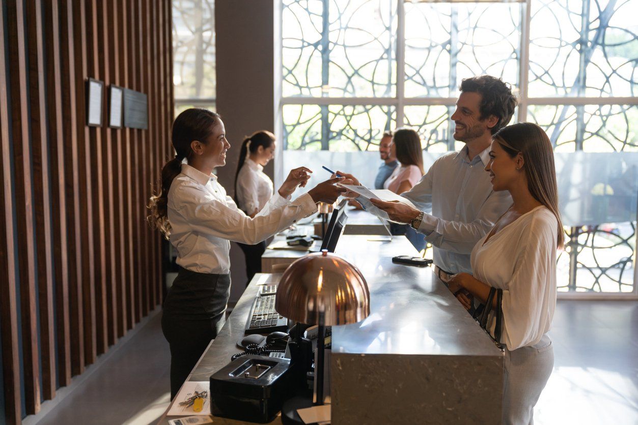 Social media management plan for hotels - front desk agents assisting guests in checking in.