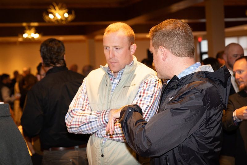 Two men are talking to each other in a crowded room.