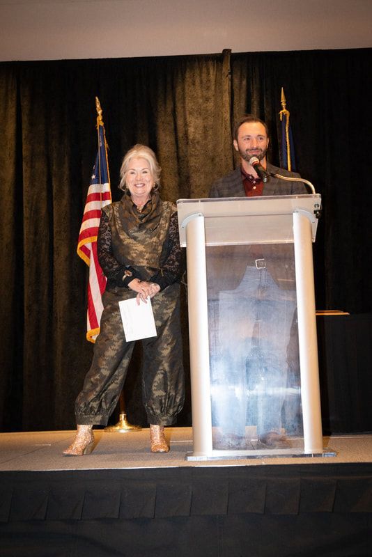 A man and a woman are standing at a podium giving a speech.
