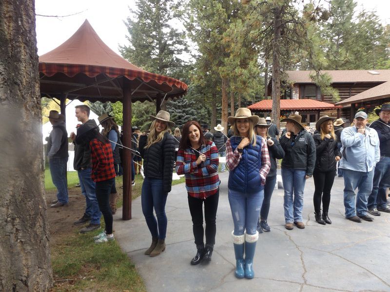 A group of people wearing cowboy hats are standing in a line