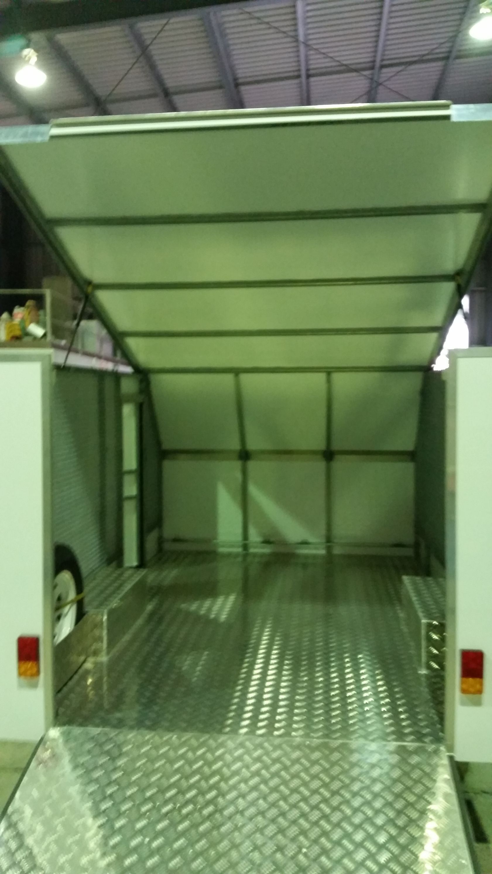 The inside of a trailer with the door open in a warehouse.