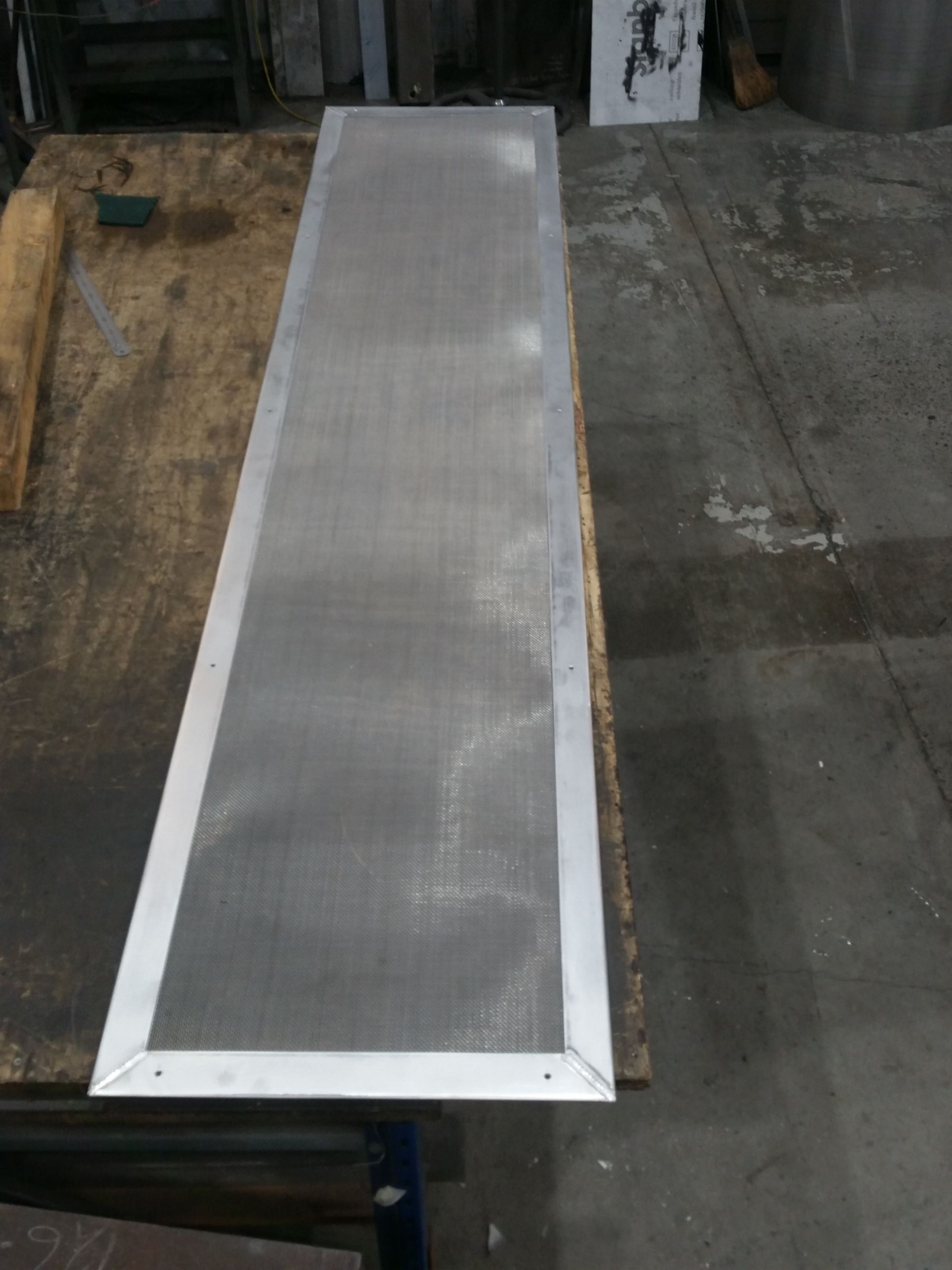 A long piece of metal is sitting on top of a wooden table.