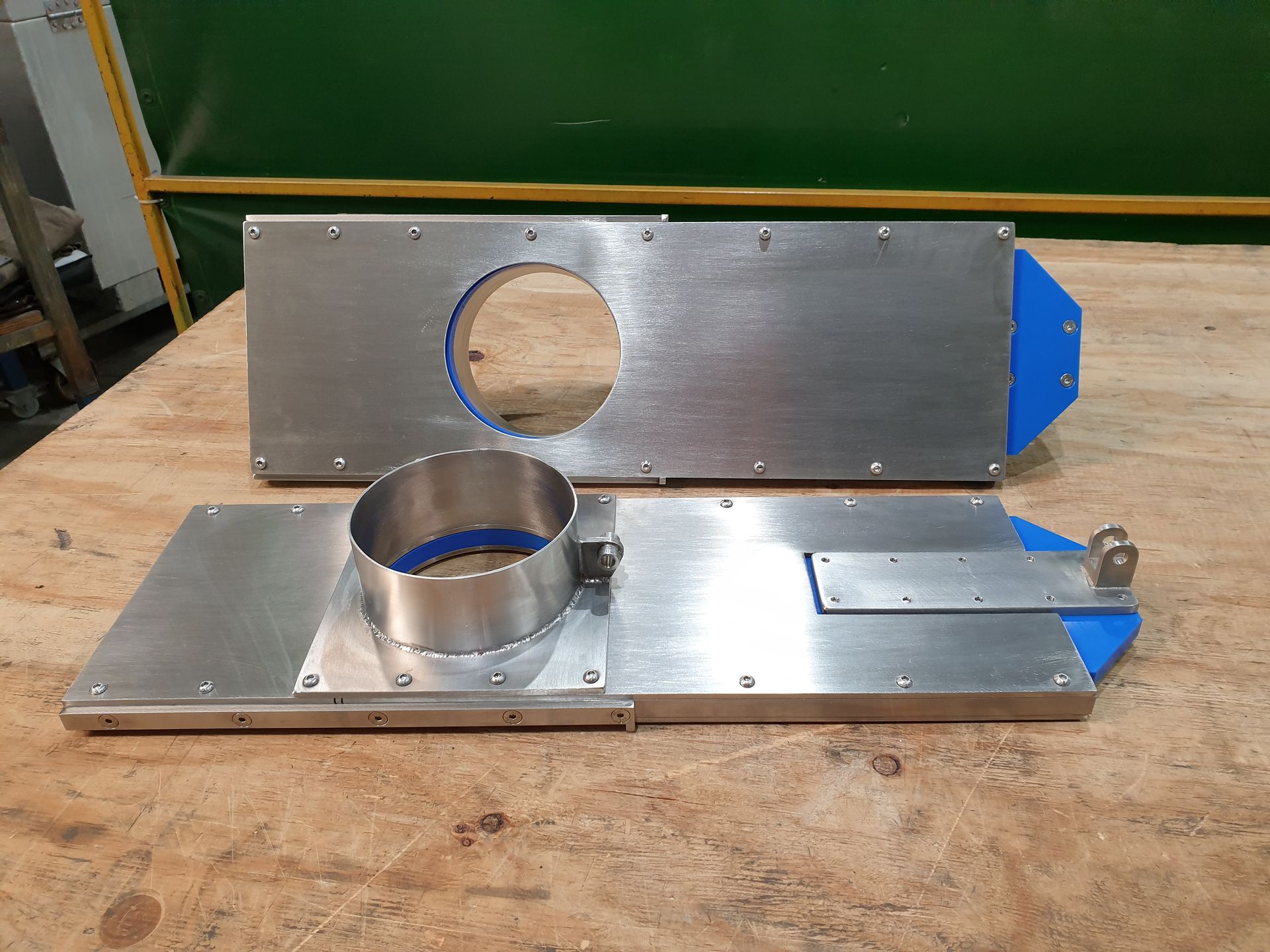Two pieces of metal are sitting on top of a wooden table.