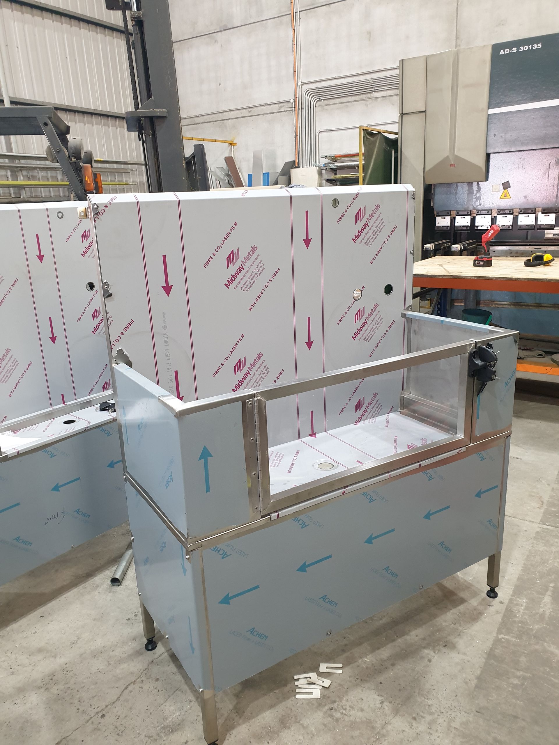 A stainless steel cabinet is being built in a factory.