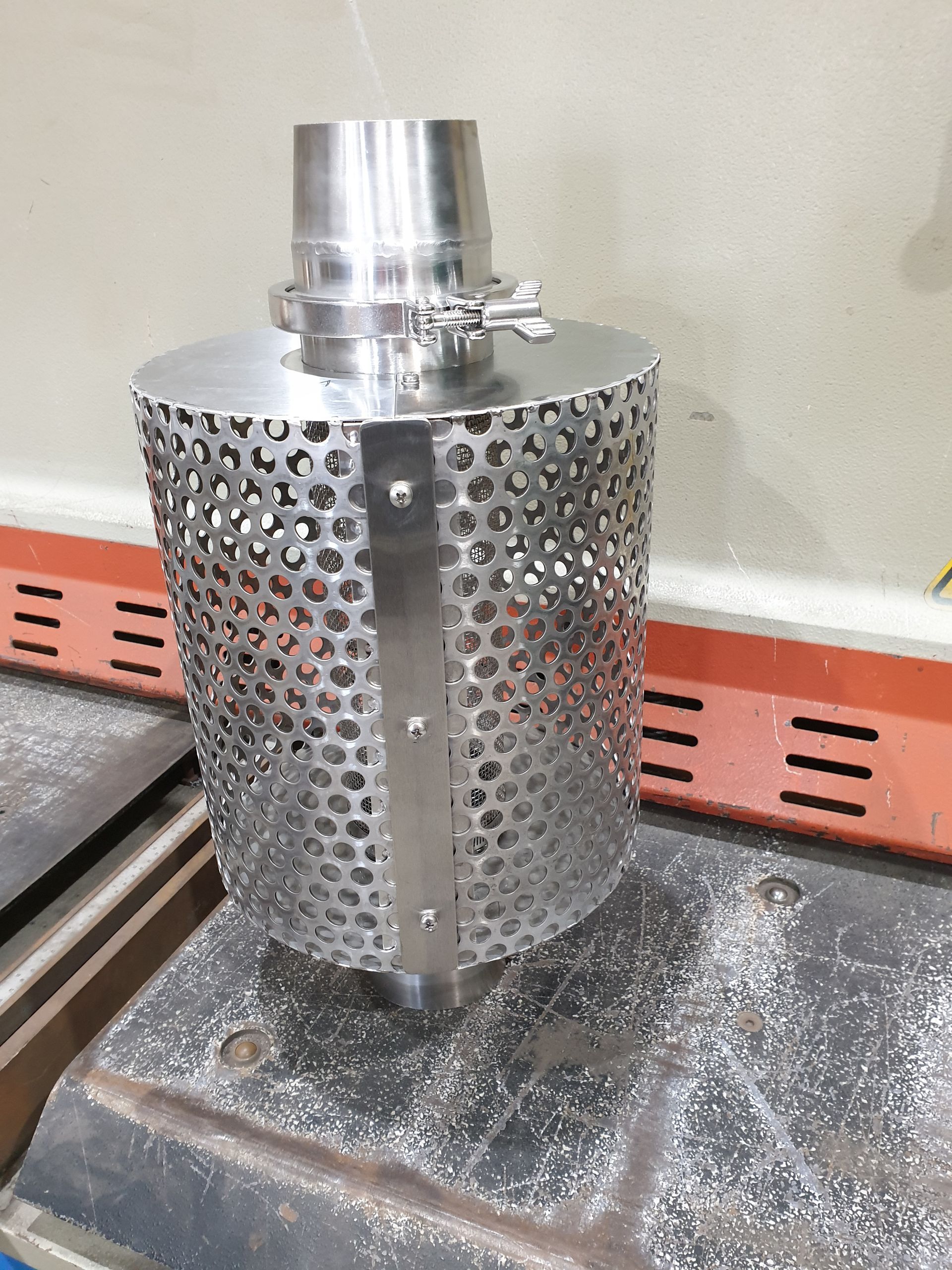 A metal object with holes in it is sitting on a table.