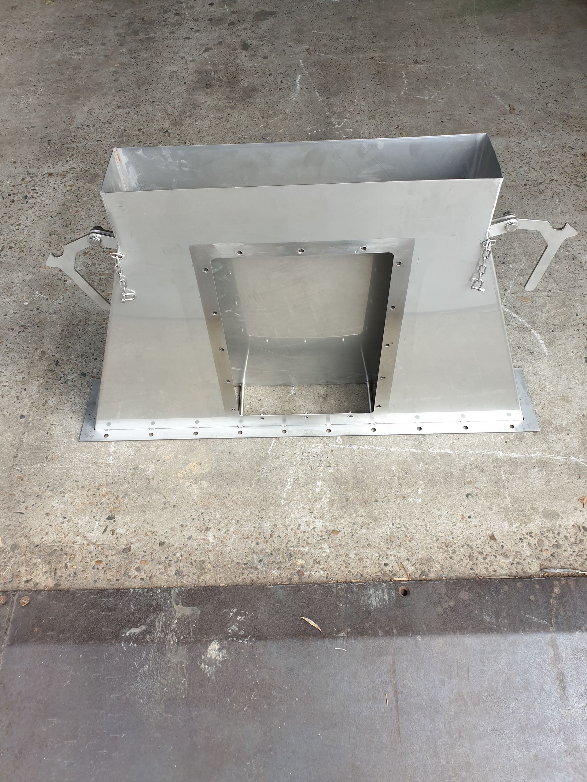 A metal object is sitting on a concrete surface.