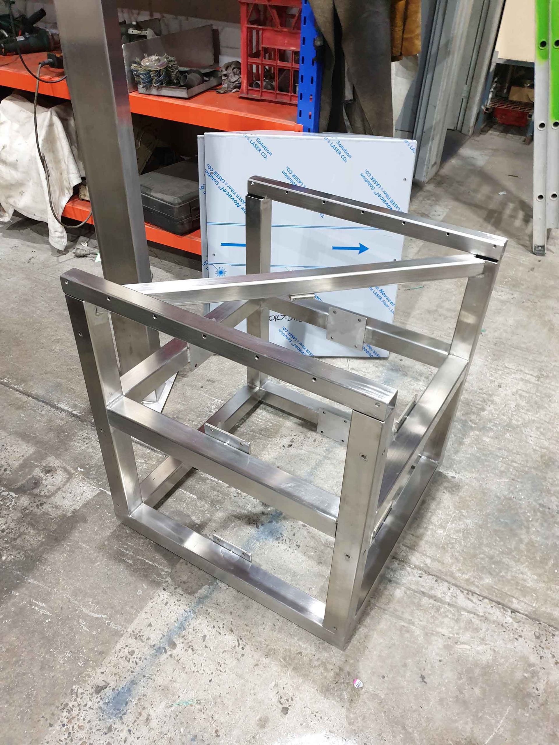 A stainless steel frame is sitting on the ground in a warehouse.