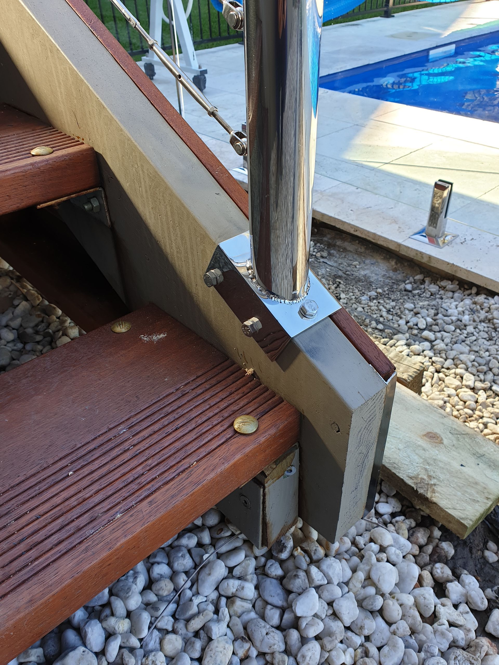 A close up of a wooden staircase next to a pool.