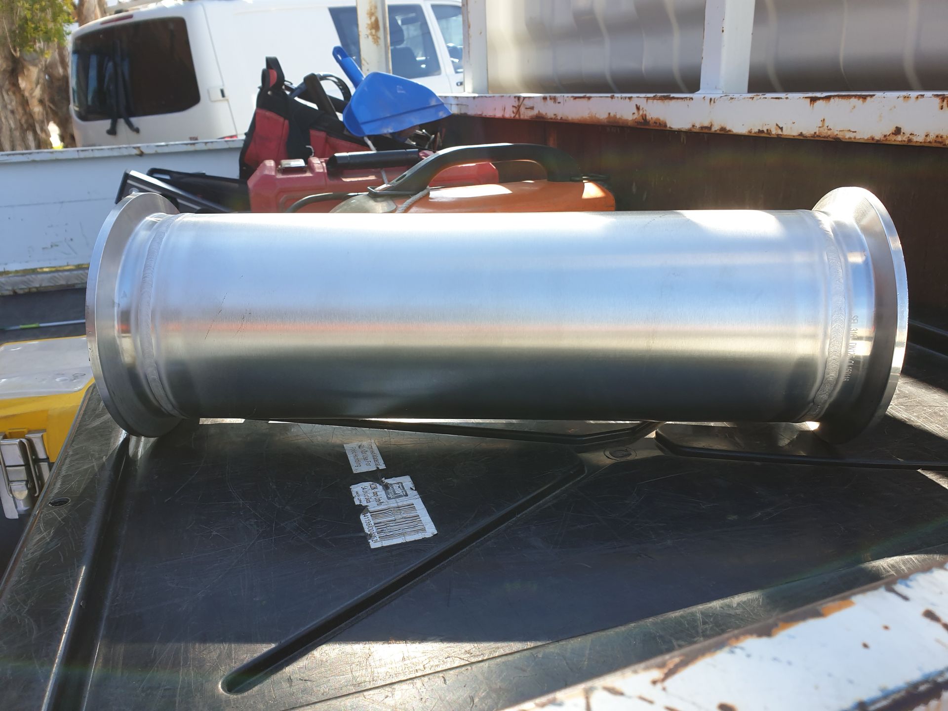 A large metal pipe is sitting on top of a truck