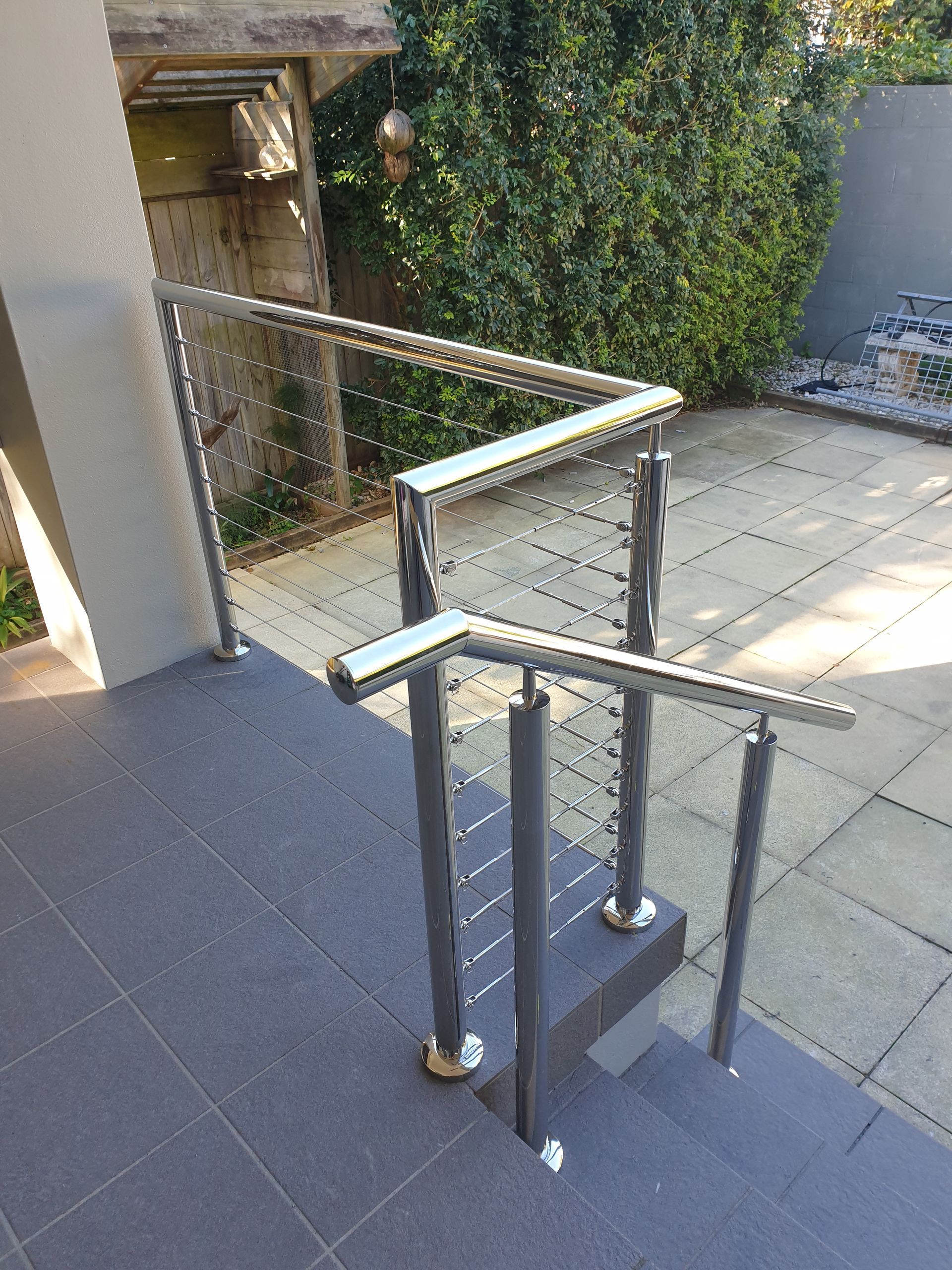 A staircase with a stainless steel railing and a glass railing.