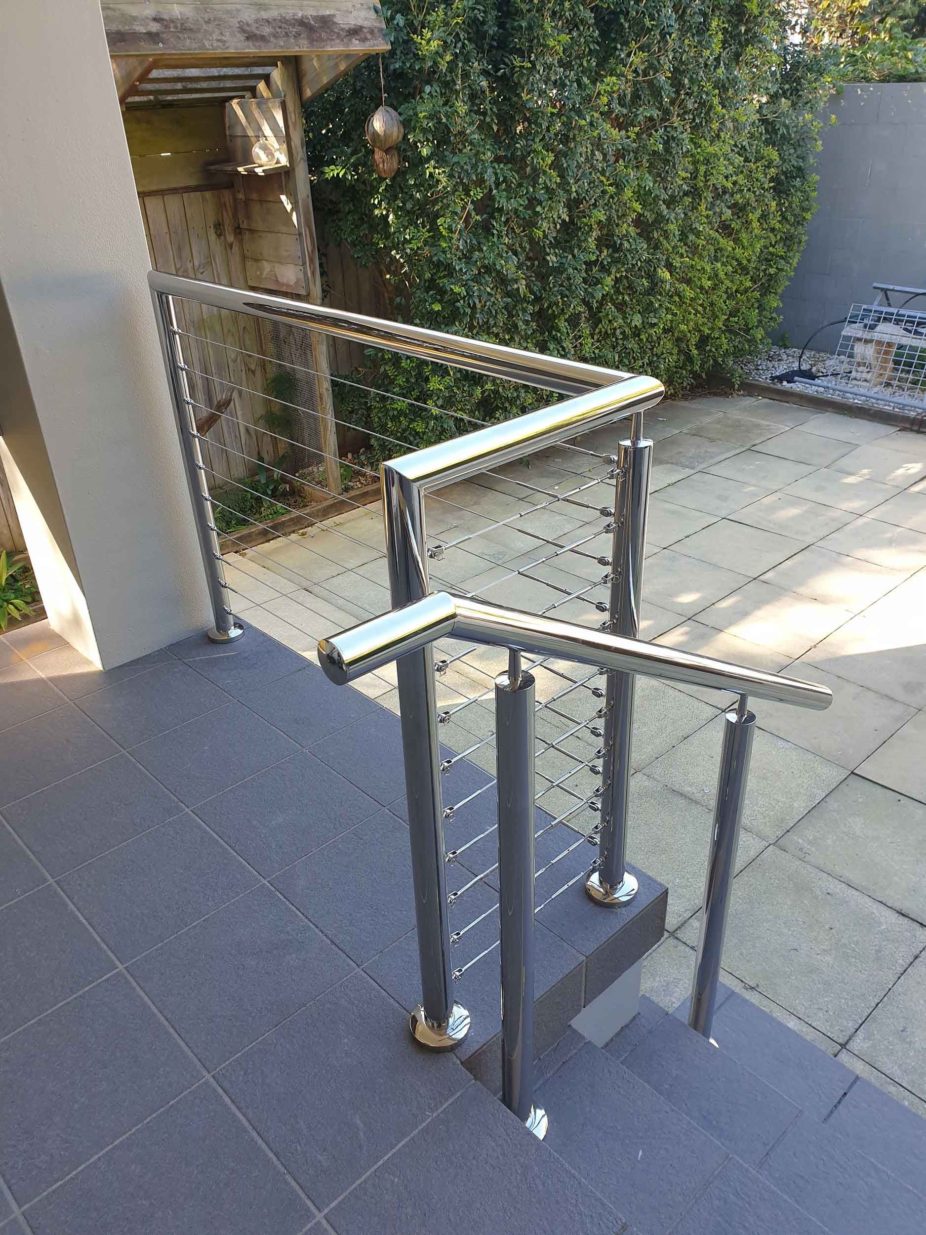 A staircase with a stainless steel railing and a glass railing.