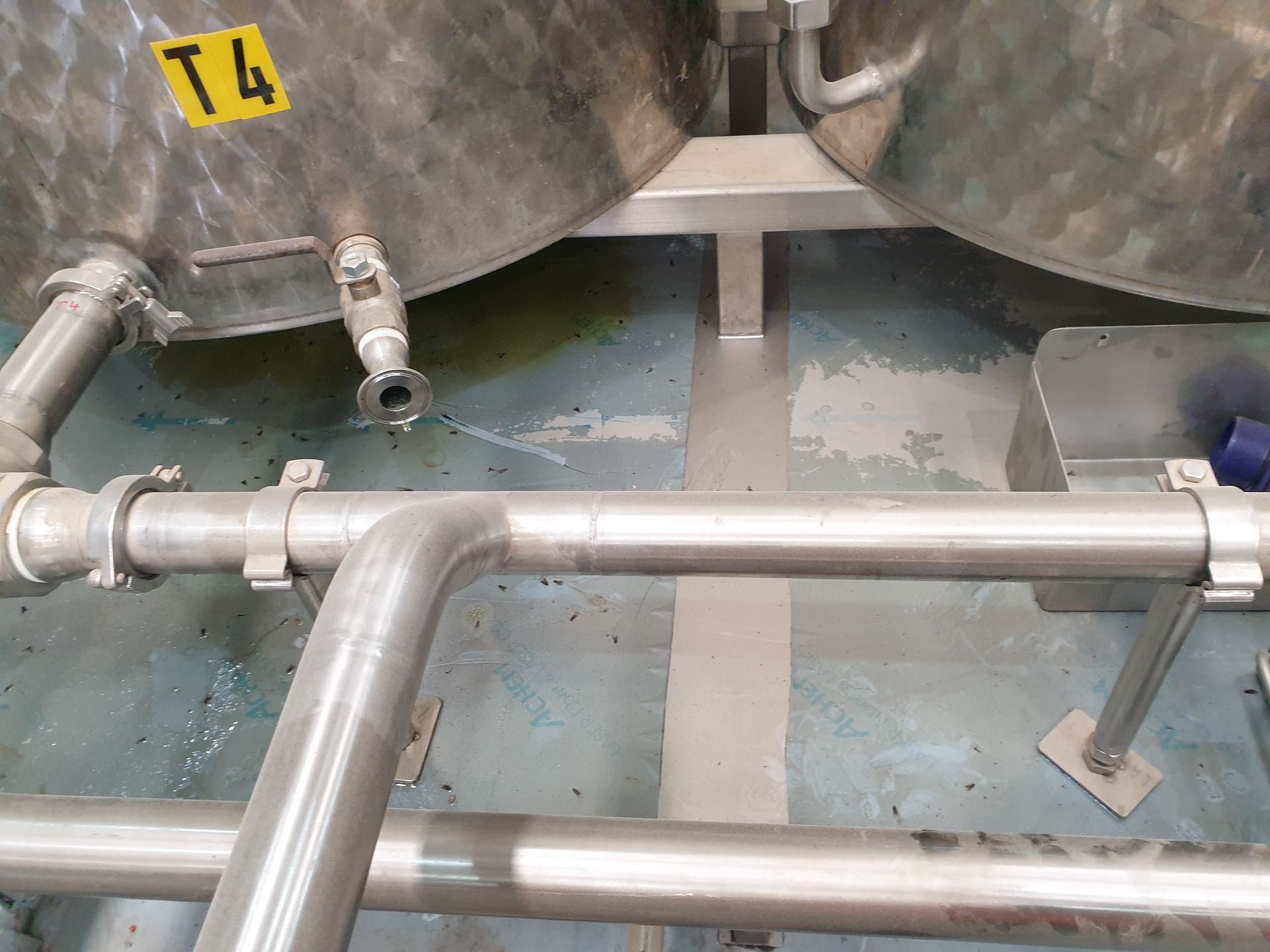 A stainless steel pipe with a yellow sticker that says t4