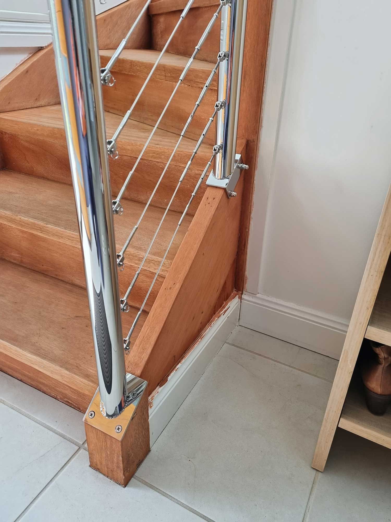 A close up of a wooden staircase with a metal railing.