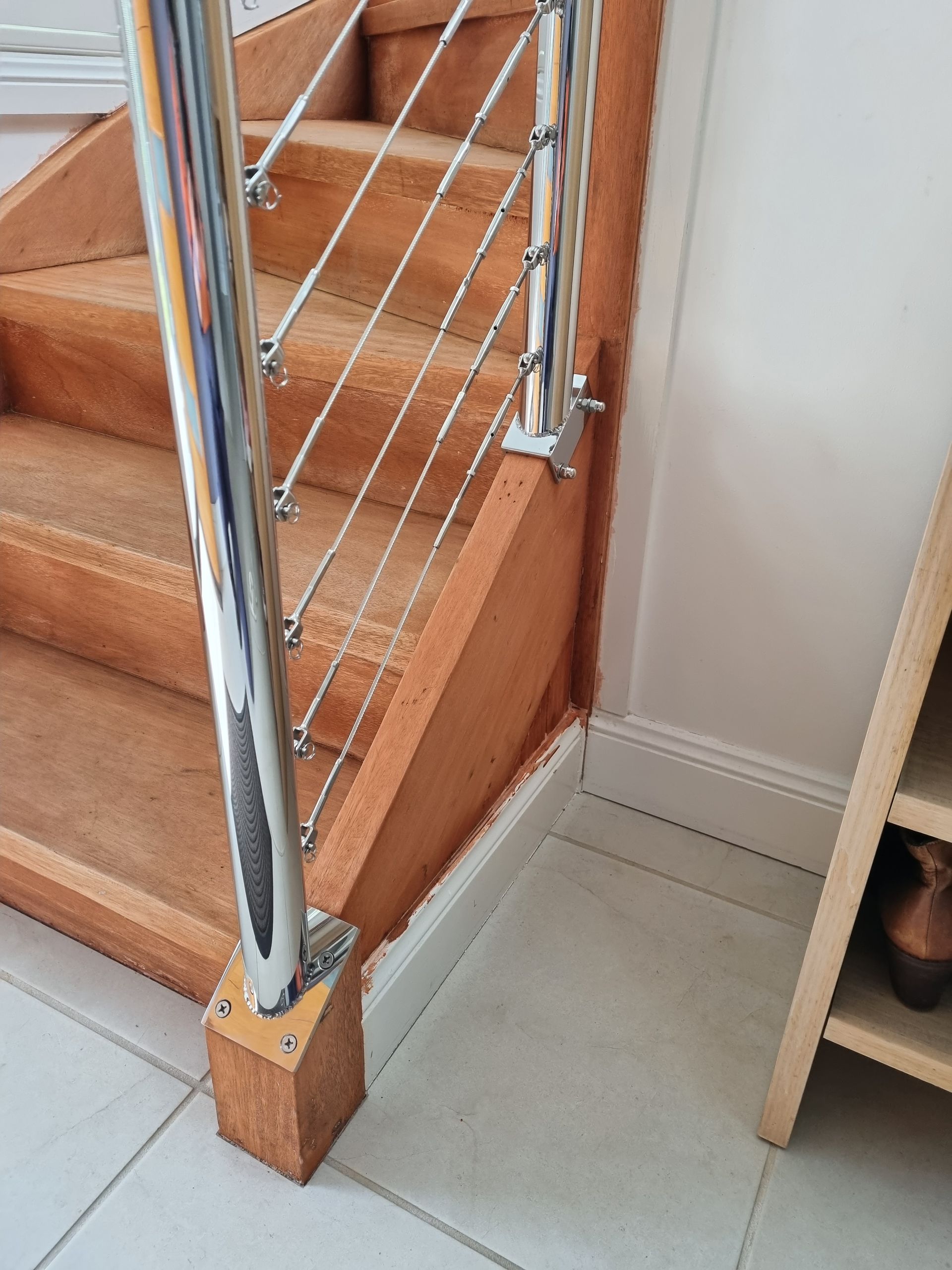A close up of a wooden staircase with a metal railing