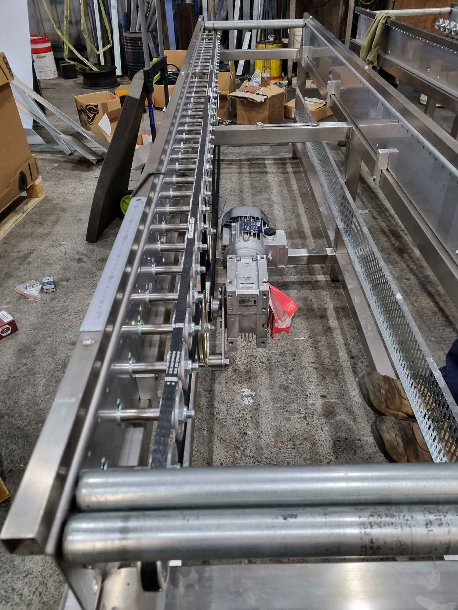 A stainless steel conveyor belt is being built in a factory.