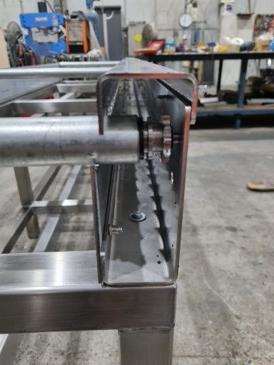 A stainless steel table is being built in a factory.