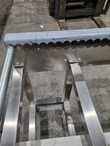 A stainless steel table with a forklift in the background.