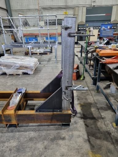 A metal structure is sitting on a concrete floor in a factory.