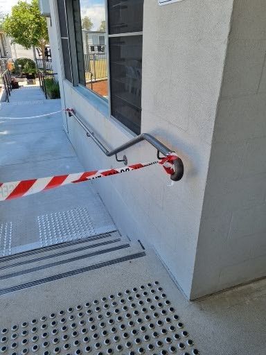 A building with stairs and a red and white tape on the side of it.
