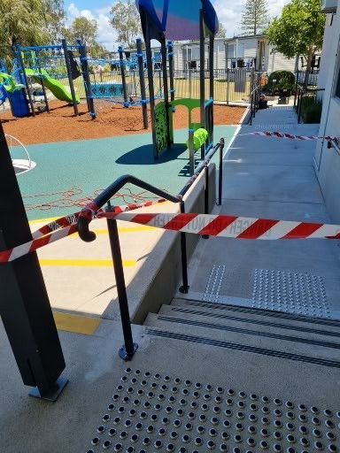 A playground with a red and white tape covering the stairs