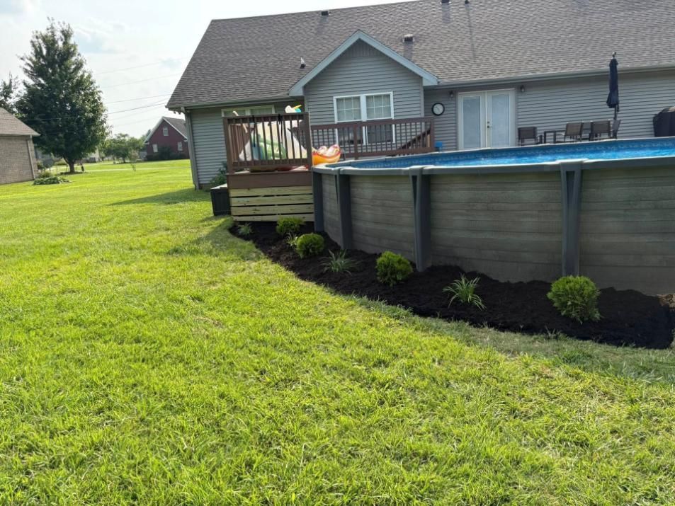 Backyard with above-ground pool, wooden deck, and green lawn beside a house