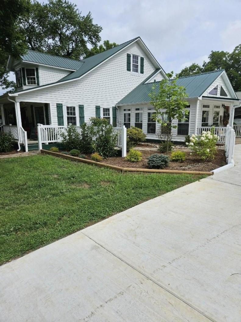 White house with front garden and wide concrete driveway under cloudy sky
