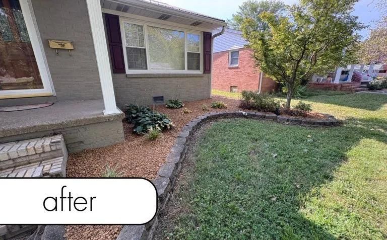 House front yard with fresh mulch border, stone edging, and trimmed green lawn.