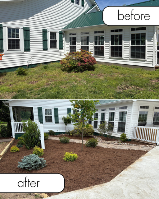 Gray house exterior with a retaining wall, small shrubs, and a mulched slope